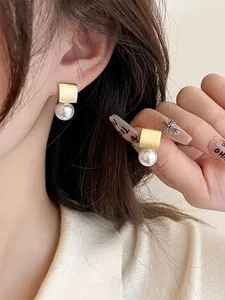 Détail des boucles d'oreilles carrées en argent S925 avec perles de coquillage rondes