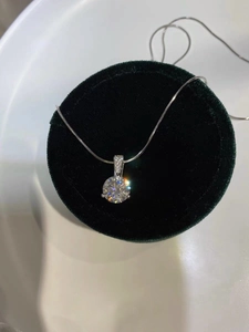 Detailed shot of a silver necklace with a brilliant diamond pendant in a velvet box