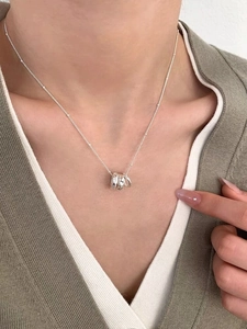 Detail of S925 sterling silver triple ring necklace with zircon on a model collarbone