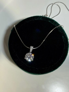Detailed shot of S925 silver necklace with sparkling round diamond on a velvet box