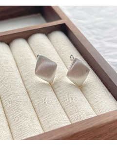 Detailed view of S925 sterling silver rhombus earrings with brushed matte finish on velvet