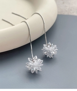 Detailed macro of S925 sterling silver long tassel earrings with crystal flower charms