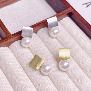 Boucles d'oreilles carrées en argent S925 et or avec perles sur plateau de velours beige