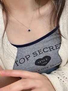 Close-up of S925 sterling silver heart necklace with black agate on a woman neck