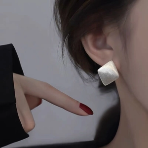 Close-up of geometric S925 sterling silver square earrings with a brushed matte texture