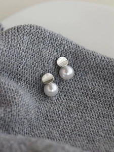 Dettaglio degli orecchini a perno in argento S925 e perla su fondo in maglia