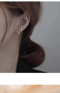 Close-up of S925 sterling silver star stud earrings with zircon inlay on model's ear