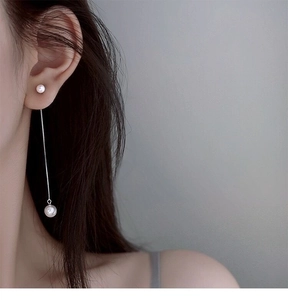 Détail de boucles d'oreilles pendantes en argent S925 avec perles sur un modèle
