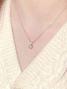 Detailed view of rose gold cherry blossom pendant with pink stone on model