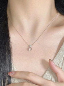 Close-up of a rose gold cherry blossom necklace with pink crystals on woman's neck