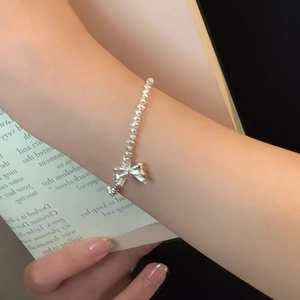 Close-up of S925 sterling silver beaded bracelet with 3D bow charm on a female wrist