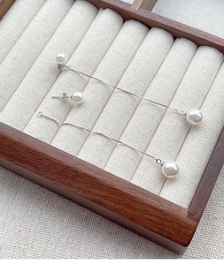 Détails macro de boucles d'oreilles en argent S925 et perle sur un plateau en velours
