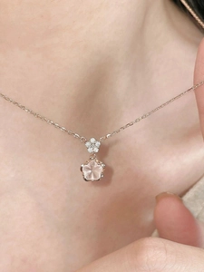 Detail of rose gold cherry blossom necklace with pink petals and small diamonds on skin