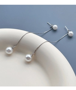 Détail de boucles d'oreilles pendantes en argent S925 avec perles blanches rondes