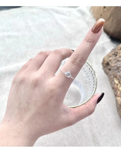 Detailed view of heart-shaped moonstone silver ring with adjustable link chain on finger