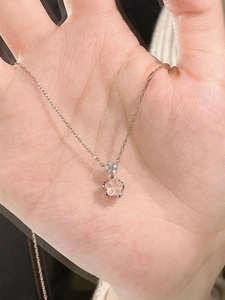 Close-up of pink cherry blossom pendant in rose gold finish held in hand