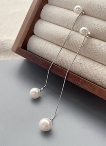 Détail de boucles d'oreilles pendantes en argent S925 avec doubles perles et chaîne fine