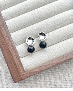 Close-up of S925 sterling silver concave stud earrings with black onyx bead on a tray