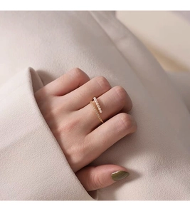 Detail of a gold double-layer silver ring with tiny white pearls and sparkling zircons