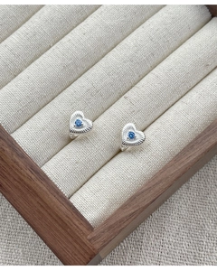 Détail de boucle d'oreille cœur en argent S925 avec pierre bleue et gravure fine
