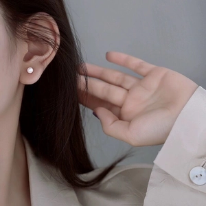 Boucles d'oreilles minimalistes en argent S925 avec perles portées par un mannequin de profil