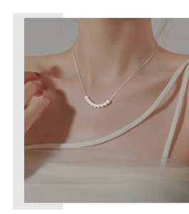 Gros plan sur une chaîne en argent sterling S925 avec sept petites perles élégantes