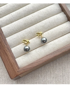 Detail shot of a S925 silver knot pearl earring with dark gray pearl in a jewelry box