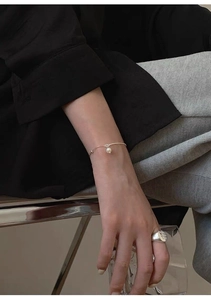 Detail view of S925 sterling silver chain with a freshwater pearl and a wide silver ring