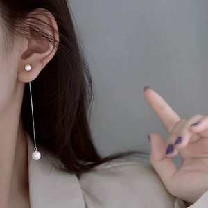 Élégantes boucles d'oreilles longues en argent S925 avec deux perles sur un modèle