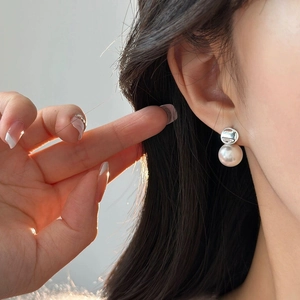 Eleganti orecchini a lobo in argento S925 con perle bianche su una modella femminile