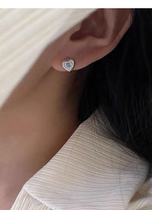 Détail de la boucle d'oreille cœur en argent S925 avec texture et pierre bleue