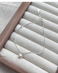 Close-up of S925 sterling silver chain bracelet featuring a round freshwater pearl pendant