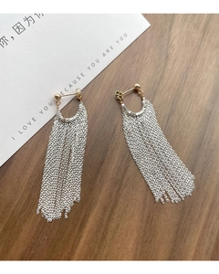Détail de boucles d'oreilles longues à pampilles en argent avec clou doré sur bois