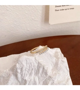 Close-up of golden double-layered S925 silver ring with pearls and tiny diamonds