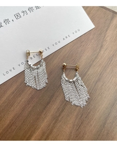 Détail de boucles d'oreilles pampilles en argent S925 avec clous dorés sur bois