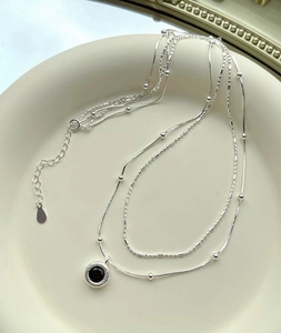 Detail of S925 sterling silver layered necklace featuring black onyx pendant and multi-strand chains