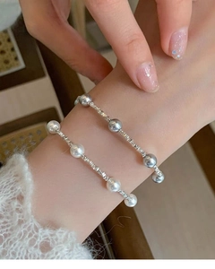 Nahaufnahme eleganter S925 Sterlingsilber-Armbänder mit weißen und grauen Perlen am Handgelenk
