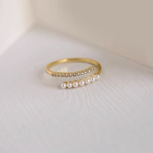 Detail of S925 silver gold-plated ring with zircon row and six small white pearls