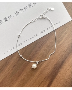 Macro detail of S925 silver chain with freshwater pearl pendant and S925 hallmark stamp
