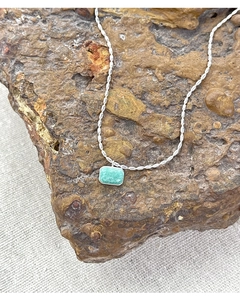 Macro shot of S925 silver necklace with green amazonite square pendant on brown ore