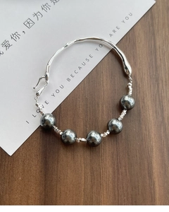 Detail of S925 silver wavy cuff bracelet featuring dark grey pearls and S-hook closure