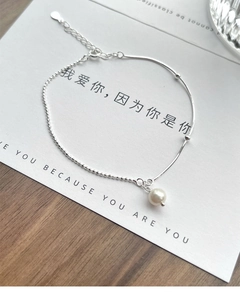 Macro view of S925 sterling silver pearl bracelet on a romantic greeting card