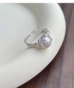 Dettaglio dell'anello in argento S925 con texture irregolare e perla d'acqua dolce bianca