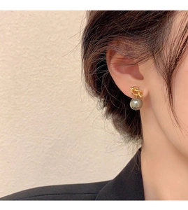 Close-up of a model wearing a gold knot pearl drop earring in S925 sterling silver