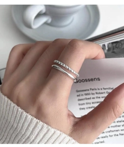 Detail view of a double-layered S925 sterling silver ring worn on a finger