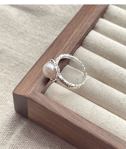 Dettaglio dell'anello in argento S925 a trama irregolare con una perla bianca