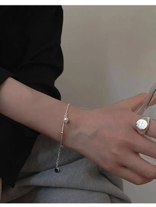 Detail view of S925 silver bracelet with freshwater pearl and engraved ring on model's hand