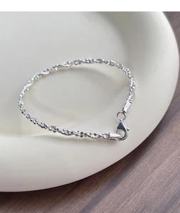Close-up of S925 sterling silver beaded bracelet with lobster clasp on ceramic tray