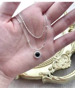 Detail of S925 silver double layer necklace with black agate pendant and twist texture