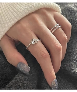 Detailed close-up of a S925 silver three-piece ring set with heart and textured bands